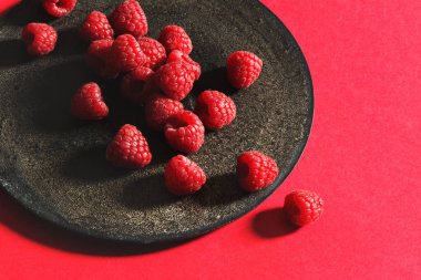 Rustik siyah plaka üzerinde taze frambuaz