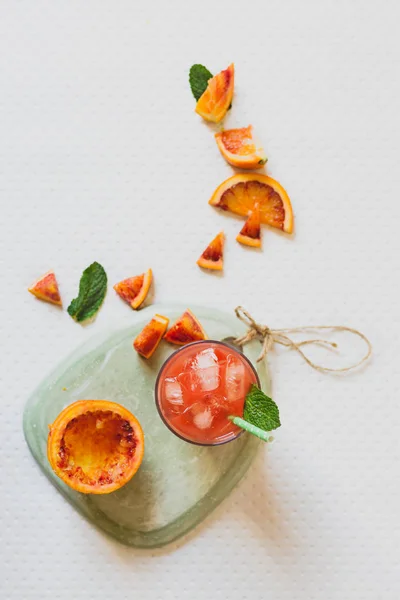 Zumo de naranjas rojas de sangre, fruta fresca, sobre la mesa de menta verde — Foto de Stock