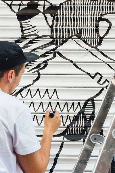 Muchacho graffiti, pintado con rotulador, en la persiana de una tienda — Foto de Stock