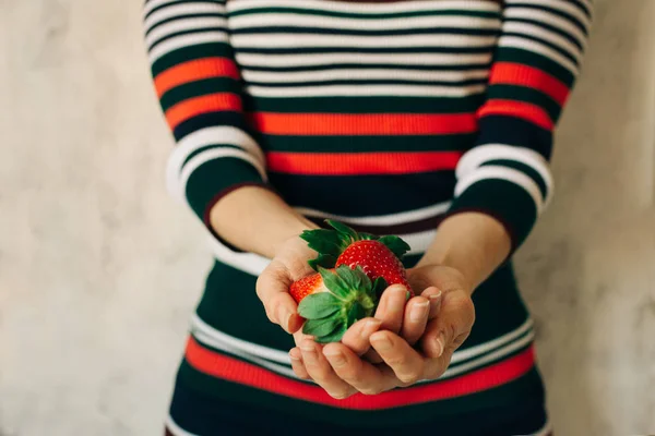 Mujer sostiene fresas en sus manos —  Fotos de Stock