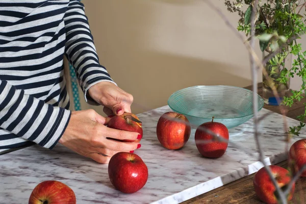 Femme coupant des pommes sur la table — Photo