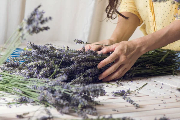 Florist at work: woman creating bouquet of natural lavender flow