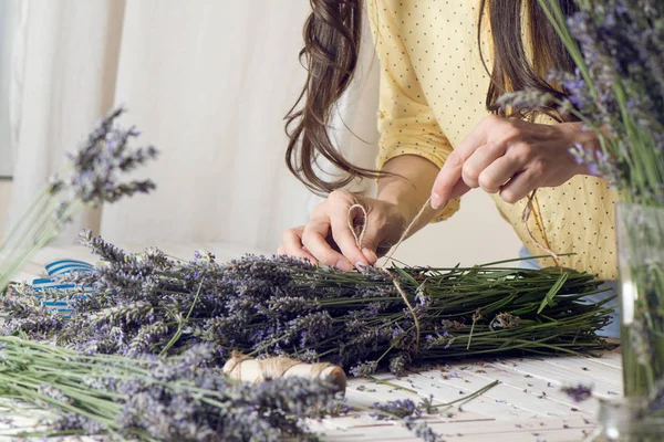 Florist at work: woman creating bouquet of natural lavender flow