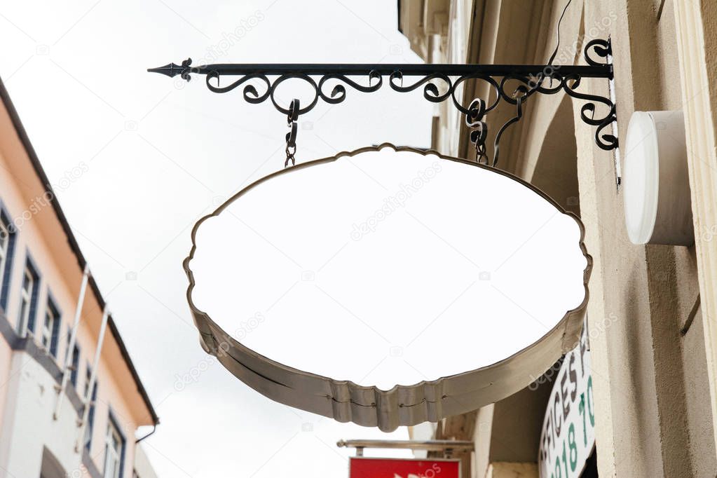 Blank Oval Signage hanging from wrought iron bracket