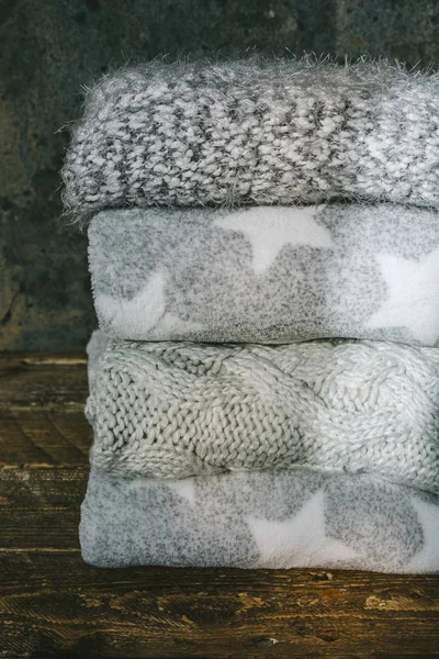 Σωρός από πλεκτό χειμωνιάτικα ρούχα σε ξύλινο υπόβαθρο, πουλόβερ, k — Φωτογραφία Αρχείου