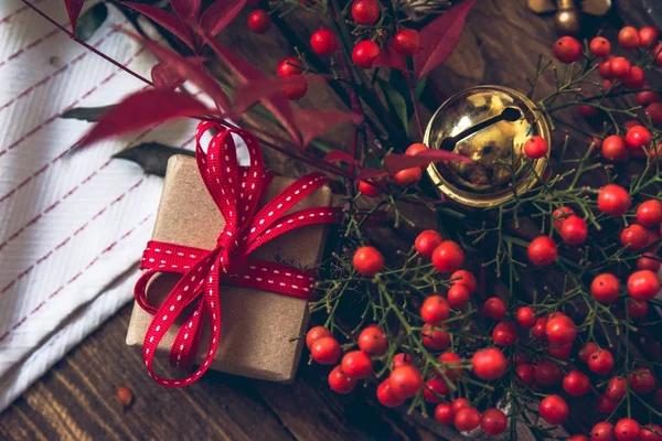 Caja de regalo, envuelta en papel reciclado y lazo rojo sobre fondo de madera — Foto de Stock