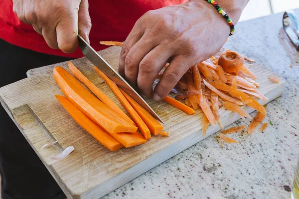 man cooking, cut carrot julienne style