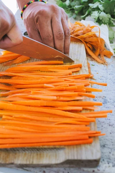 Man's hands, cut carrot julienne style — Stock Photo, Image