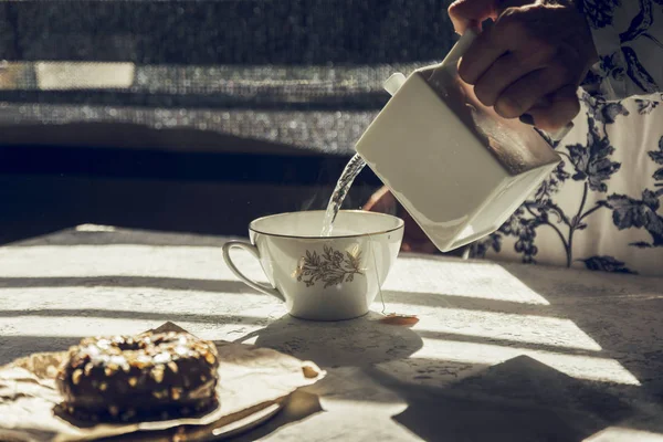 Mujer con tetera de agua caliente preparando té —  Fotos de Stock