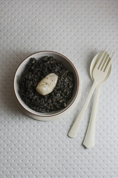 Svart ris med bläckfisk, på svart cement maträtt — Stockfoto