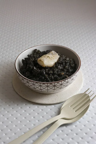 Svart ris med bläckfisk, på svart cement maträtt — Stockfoto