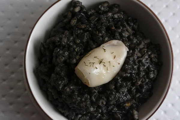 Black rice with cuttlefish, on black cement dish — Stock Photo, Image