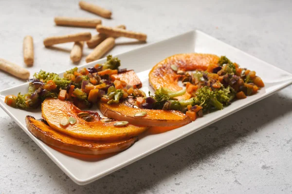 Calabaza al horno en rodajas, con brócoli y verduras variadas —  Fotos de Stock