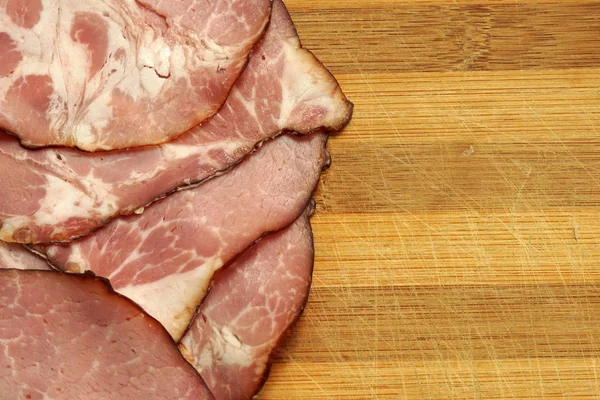 Schweineschinken in Scheiben geschnitten auf Holzboden. Nahaufnahme — Stockfoto