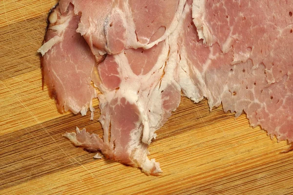 Presunto de porco fatiado no fundo de madeira. close-up — Fotografia de Stock