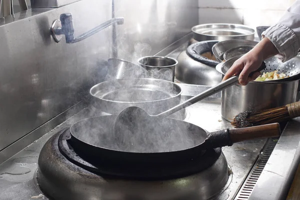 Primer plano del chef que trabaja preparando comida china Imagen de archivo