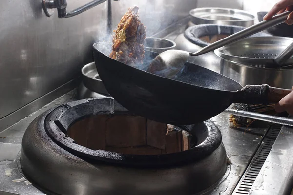 Primer plano del chef que trabaja preparando comida china Imagen de stock