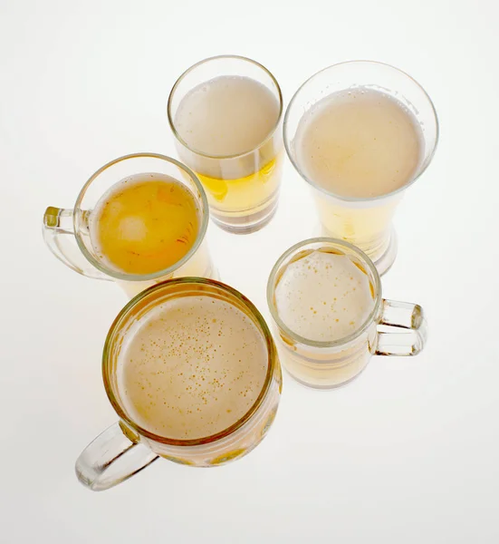Viele Gläser helles Bier auf weißem Hintergrund — Stockfoto