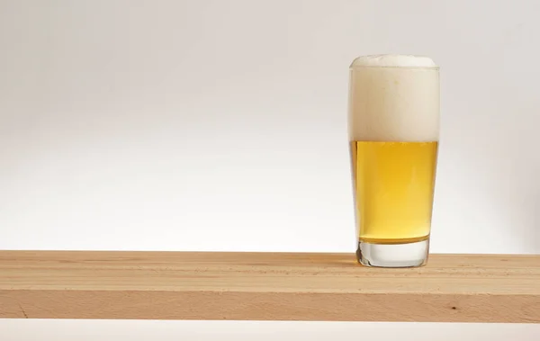 Стакан светлого пива на деревянной доске . — стоковое фото