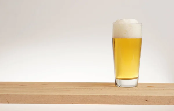 Un vaso de cerveza ligera en una tabla de madera . —  Fotos de Stock