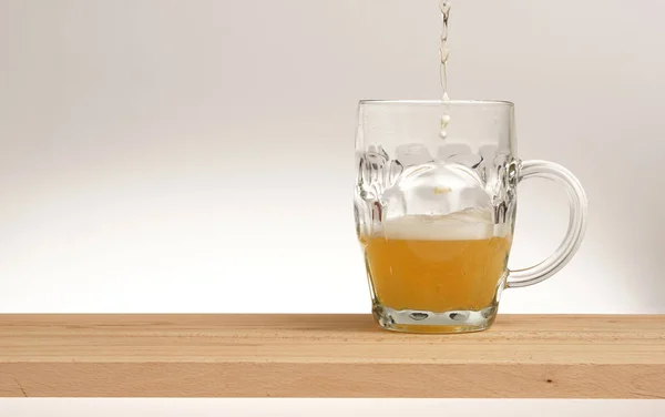 Taza de cerveza ligera en una tabla de madera . —  Fotos de Stock