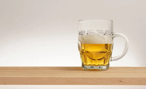 Glas leichtes Bier auf einem Holzbrett. — Stockfoto