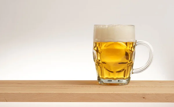 Glas leichtes Bier auf einem Holzbrett. — Stockfoto