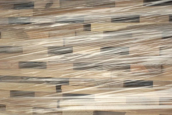 プラスチック ホイルに包まれた行に積み上げられた木の板 — ストック写真