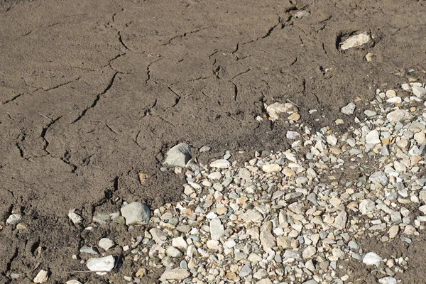 Гравийные камни, песок и земля у реки — стоковое фото