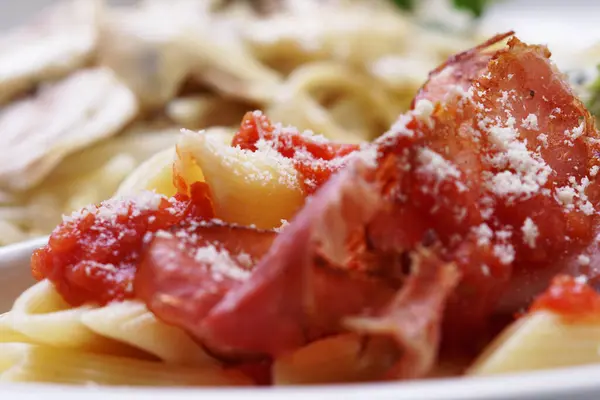 Cooked Penne macaroni with tomato sauce, parmesan and prosciutto — Stock Photo, Image