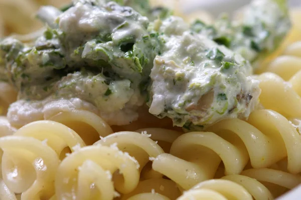 Cooked  fusilli macaroni pasta with white cheese and spinach