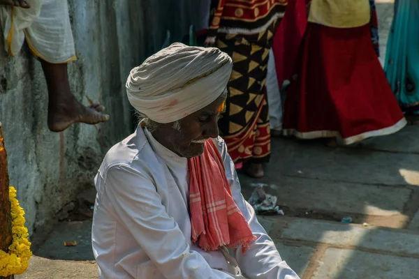 Photo d'un vieil homme seul portant un turban blanc sur les regards d'un temple hindou — Photo