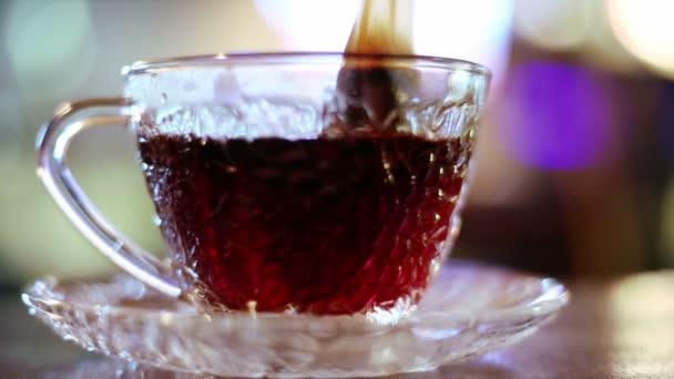 Thé noir dans un sac brassé dans une tasse en verre 