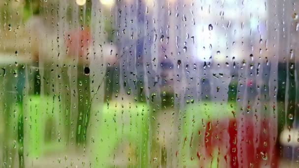 Gotas de agua deslizándose en el vidrio de la ventana de la tienda — Vídeos de Stock