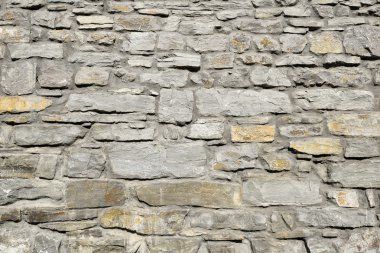 Gri desenli eski stil tasarım dekoratif kırık gerçek taş duvar yüzeyi çimento ile. Arka plan veya doku için taştan bir duvar parçası. Antika doğal stonewall arka plan