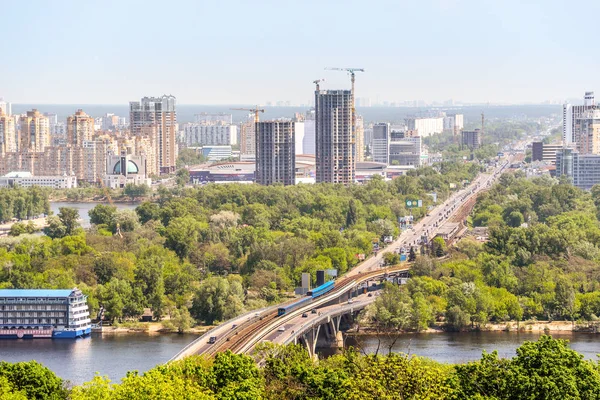 Киев, Украина - 15 мая 2017 года: красивый городской пейзаж Киева с ярко-зелеными деревьями, рекой Днепр и зданиями на левом берегу реки. Остров, Украина . — стоковое фото