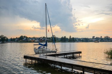 Trakai, Litvanya - 15 Ağustos 2017: Güzel bir akşam yaz Trakai göl manzara ve küçük spor ahşap iskele yat. Göl ve günbatımı gökyüzü, Trakai, Litvanya.