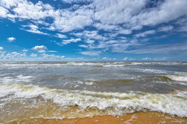 Dramatik güzel deniz manzarası ile fırtınalı denizde. Baltık Denizi, kum plaj üzerinde görüntülemek ve bulutlar ile gökyüzü. 