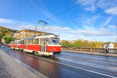 Bridge, Prague, Çek Cumhuriyeti geçiş kırmızı eski moda tramvay. Prag cityscape ve parlak mavi gökyüzü.