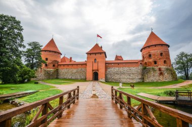 Trakai, Litvanya - 15 Ağustos 2017: Peyzaj Trakai ada kale, göl ve ahşap köprü, Litvanya. Trakai ada kale ve parlak mavi dramatik gökyüzü bulutlu. 