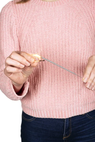 Girl in a pink knitted sweater sets fire to sparkler isolated on white — ストック写真