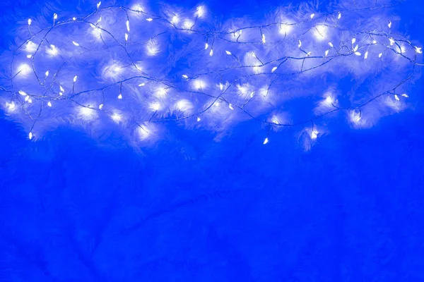 明亮蓬松的蓝色背景上的圣诞灯 — 图库照片