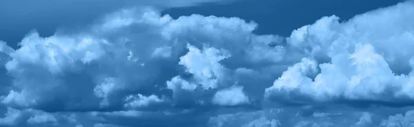 Панорамный вид на Небо с драматическими облаками. Голубые облака на небе, подходящие для фона. Облачное небо. Облачно. Длинный панорамный баннер с цветом года - классический синий — стоковое фото
