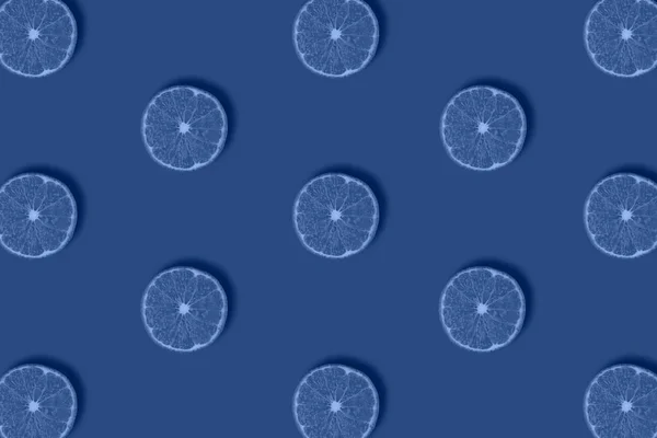 Фруктовий візерунок зі свіжих цитрусових скибочок ізольовано на синьому фоні. Плоский прошарок, вид зверху . — стокове фото