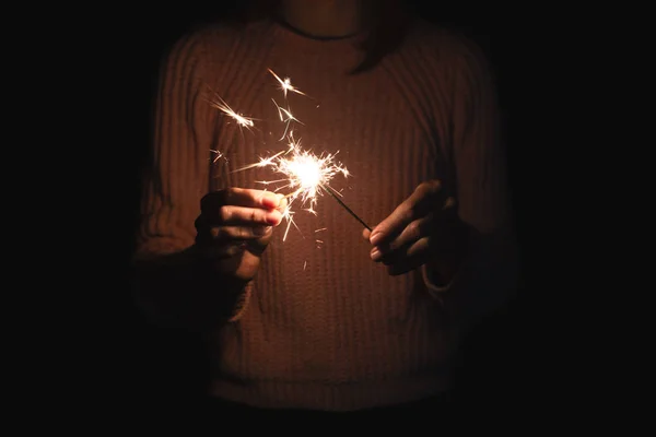 Menina ateia fogo para sparkler, fundo escuro — Fotografia de Stock