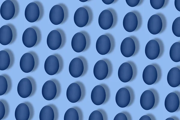 青い背景に青い卵で作られたパターン。最小限の食品コンセプト. — ストック写真