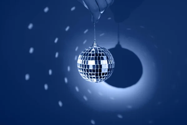 Espelho ou bola de discoteca, refletindo luzes coloridas no fundo azul clássico. Banner do partido . — Fotografia de Stock
