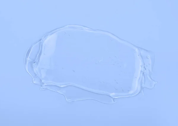 Clear gel smear isolated on blue background. Top view. — Stock Photo, Image