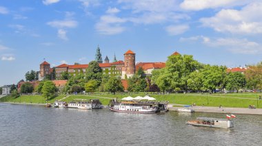 Wawel Kalesi, Vistula Nehri, bahar parkı, bisiklet yolu ve yürüyen turistler yaz manzarası