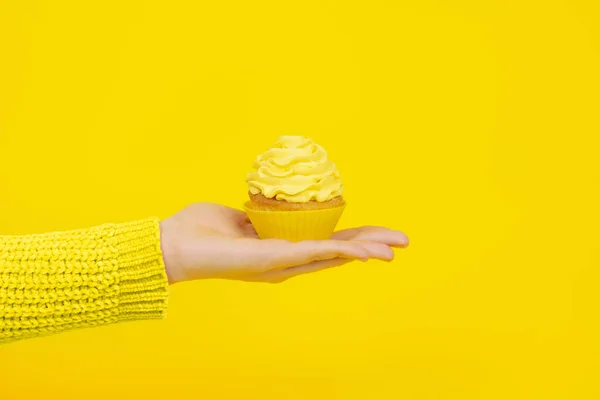 Lekkere Cupcake Vrouwelijke Hand Een Gele Achtergrond Monochroom Feestelijk Concept — Stockfoto